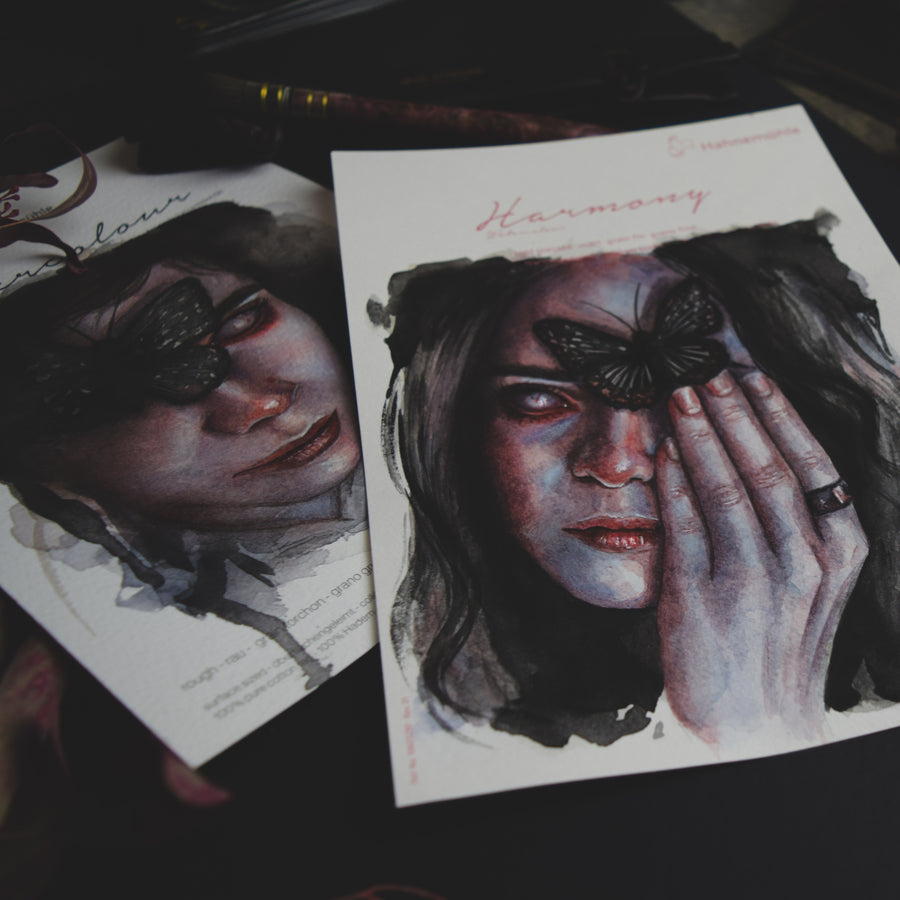 Illustration of a woman with a butterfly on her face, held by a hand, on a dark surface.